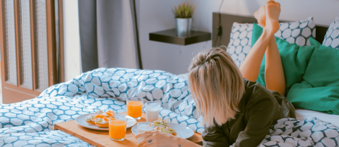 A woman laying in bed with breakfast in bed